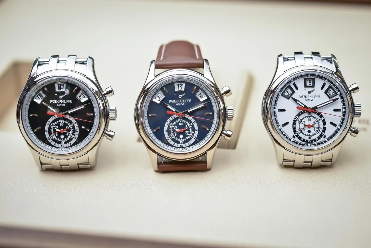 Three Patek Philippe chronograph annual calendar watches with black, blue, and white dials displayed side by side.