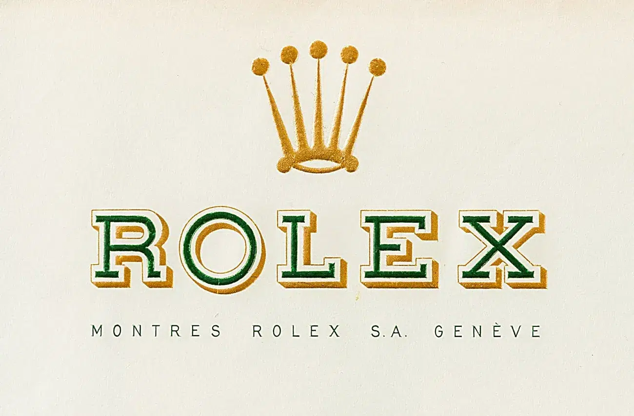 Rolex logo with green and gold letters and gold crown above, with 'Montres Rolex S.A. Genève' below on white background.