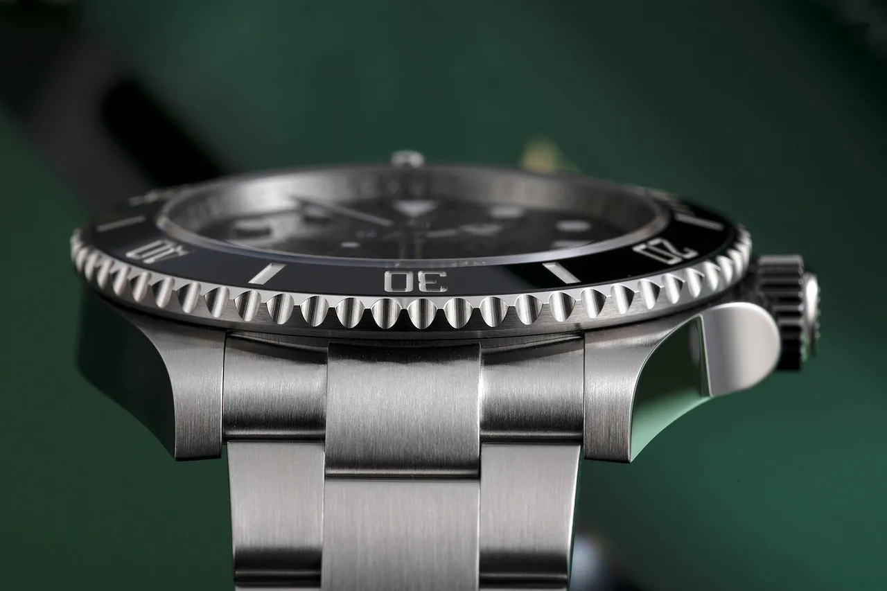 Close-up side view of a high-quality stainless steel Rolex watch with a black bezel and detailed markings